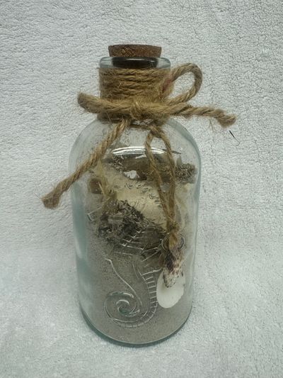 Beach sand and shells in a seahorse bottle Beach sand and shells in a seahorse bottle